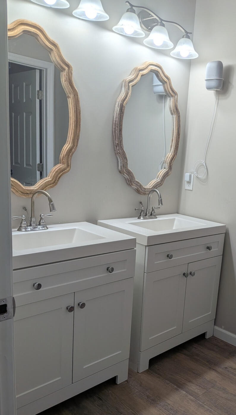 A warm, lived-in kitchen with orange walls, brown wood floors, and soft lighting. The space includes a clean island, seasonal decor, and a welcoming dining area in the background. It feels personal, vibrant, and freshly maintained.